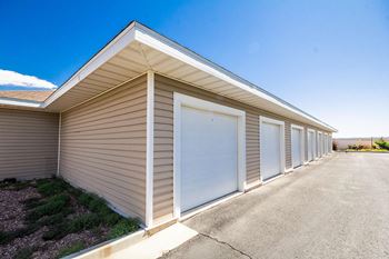 A long building with a brown siding and a white roof.
